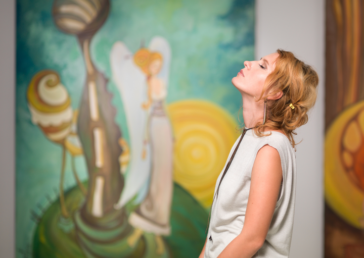 Woman in an art gallery feeling the art with closed eyes